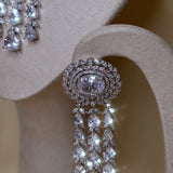 Zilverkleurige sieradenset met schitterende stenen en lange knop oorbellen