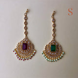 Gold colored tikka with pink or green stone