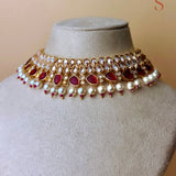 Gold-colored jewelry set with red stones and pearls