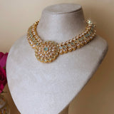 Gold colored jewelry set with light green stones and jhumka earrings