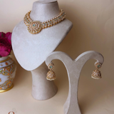 Gold colored jewelry set with light green stones and jhumka earrings