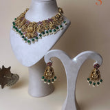 Gold-colored jewelry set with goddess Lakshmi, dark pink and green stones