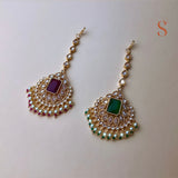 Gold colored tikka with pink or green stone