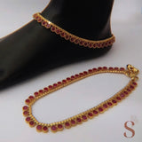 Goudkleurige enkelsieraden met donkerroze stenen (set)